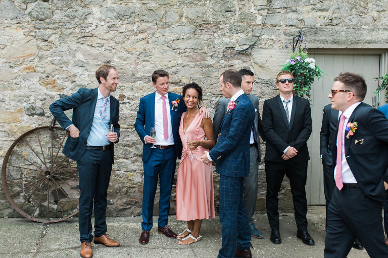 groomsmen and friends chatting at this boho and relaxed wedding in northumberland
