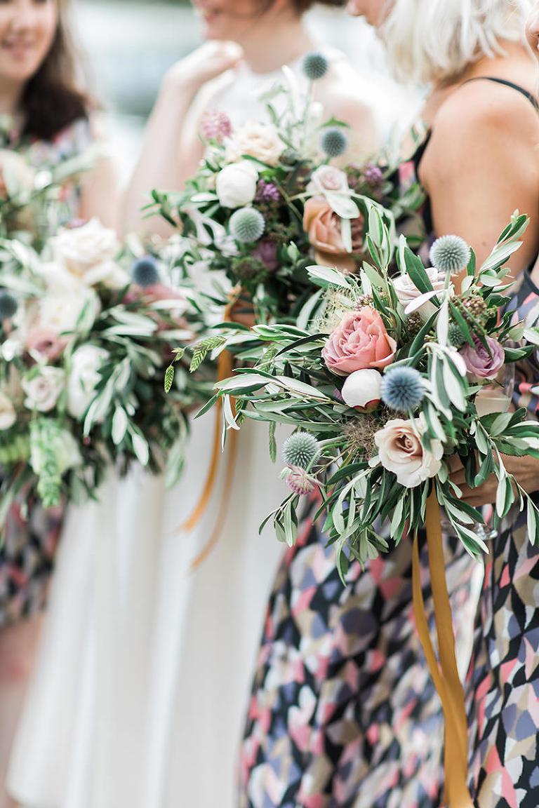 a closeup of bridesmaids holding pretty leafy bouquets